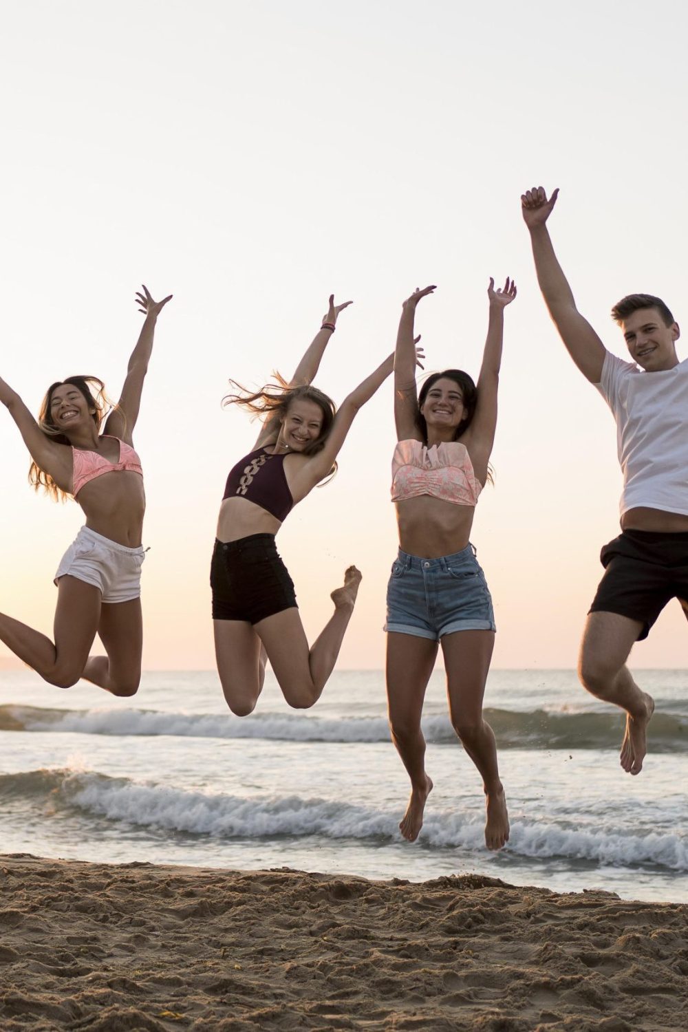 full-shot-friends-jumping-beach