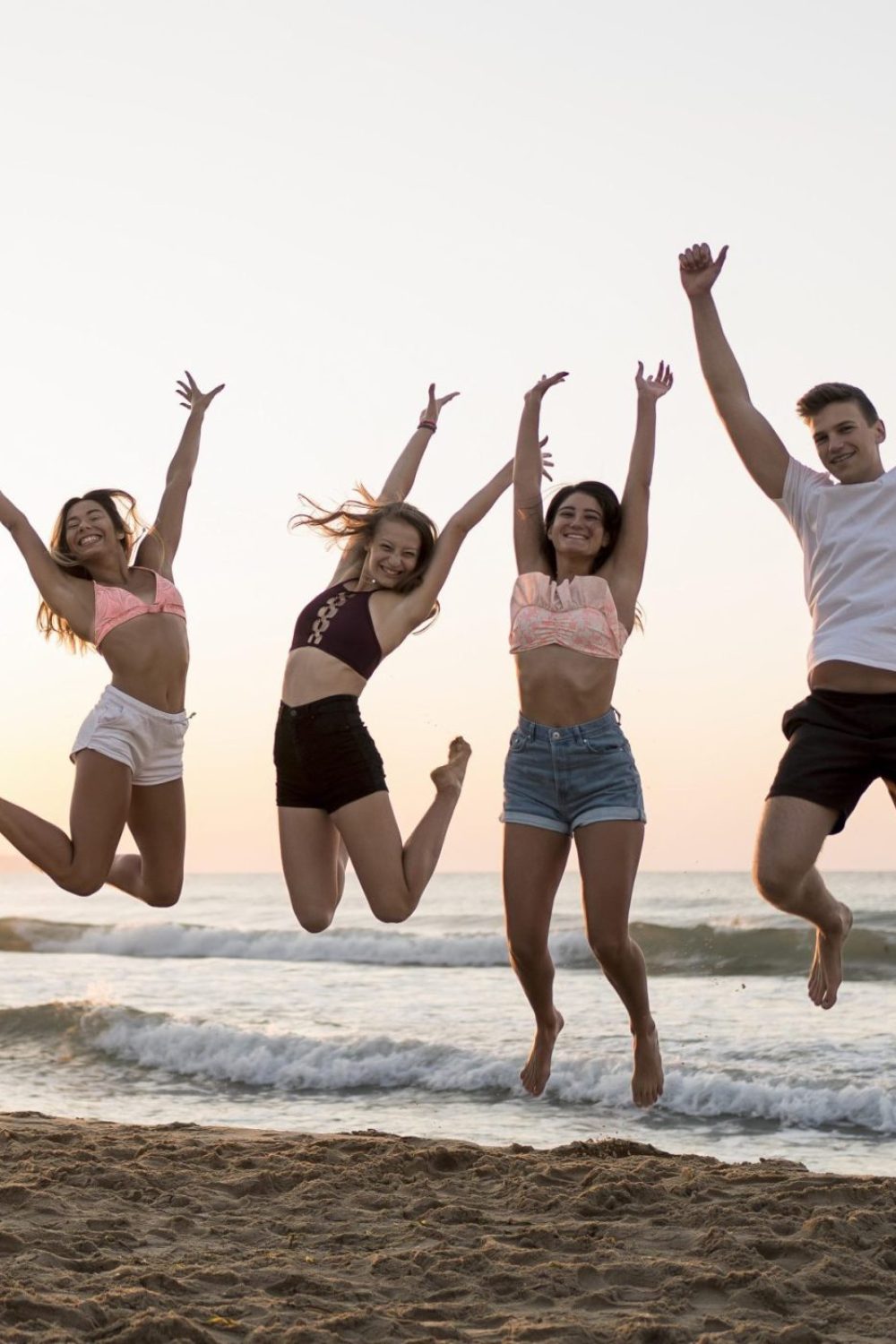 full-shot-friends-jumping-beach